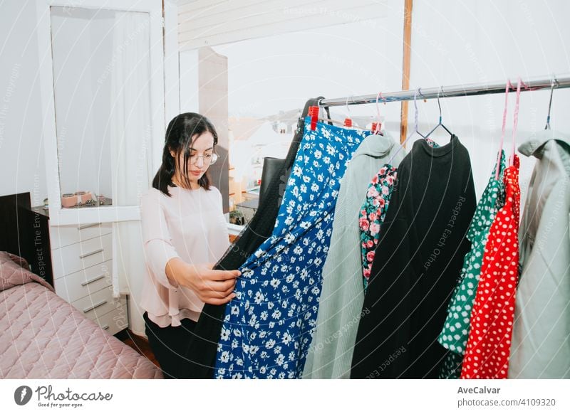 Young arab woman checking his clothes at home during a super bright day, retail and resell concept young selling clothing shopper owner customer fashion buying