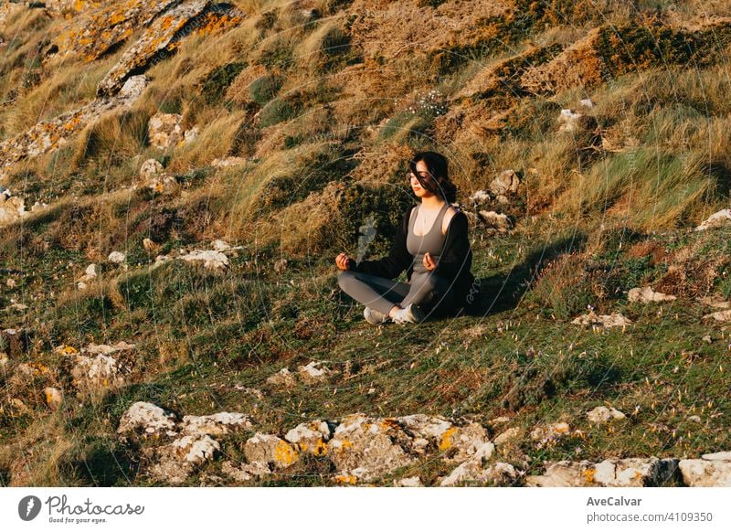 Young fit woman doing yoga in the grass sunny day with copy space lifestyle forest health fitness healthy nature exercise female green relaxation young outdoors