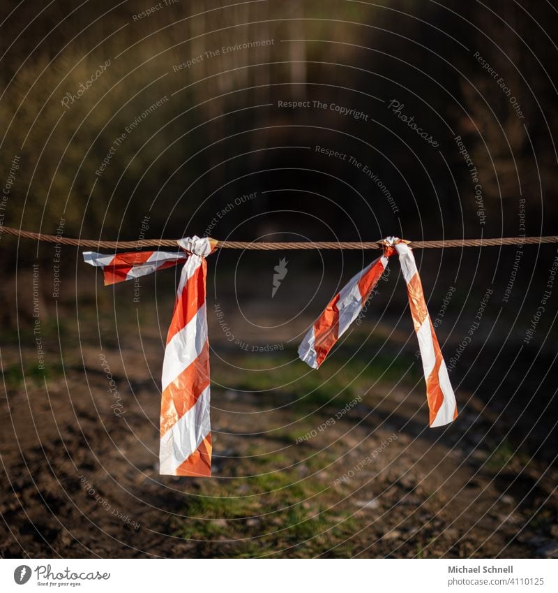 cordon barrier tape No through road Transit prohibited Barred Reddish white forest path passage Passage blocked Safety cordoned off Exterior shot Deserted