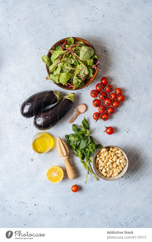 Fresh ingredients for vegetarian salad vegan healthy vegetable herb oil juicer cook kitchen dish eggplant cherry tomato spinach cashew lemon salt spice food