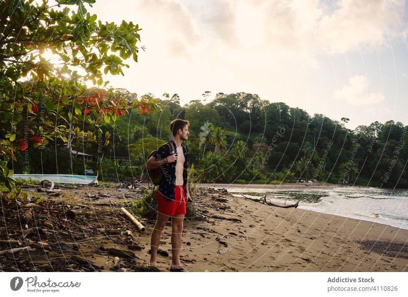 Concentrated male tourist on beach in summer man traveler enjoy seascape sandy coastline shore water tropical relax holiday tourism freedom explore wanderlust