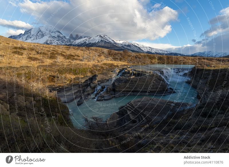 Beautiful scenery of river in valley against foggy snowy mountains cloud dramatic peak shore sky water highland island coast lake summit horizon landscape calm