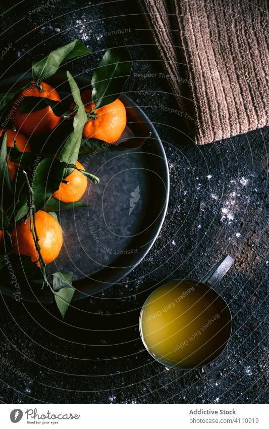 Fresh juice and tangerines on black table fresh ripe fruit rough napkin plate mug food organic citrus healthy natural delicious rustic vitamin sweet ingredient