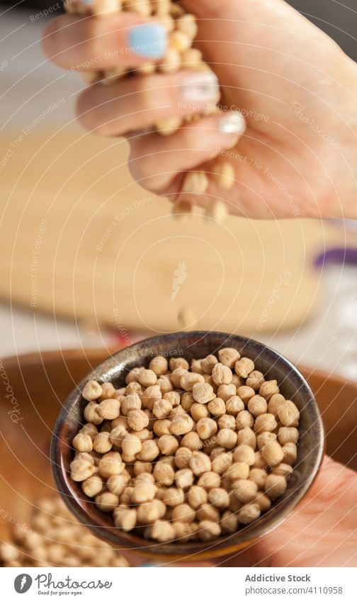 Crop woman showing handful of chickpea bowl healthy grain food natural ingredient organic heap pile nutrition fresh raw edible vegetarian many vegan product