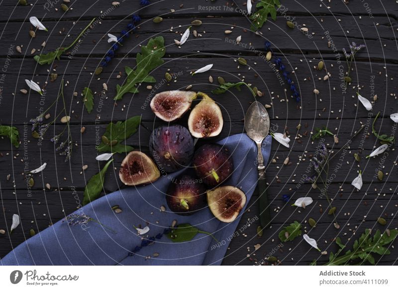 Figs and herbs near napkin and spoon fig table organic arugula food fresh half ripe natural delicious healthy fruit plant exotic vegetarian vegan snack