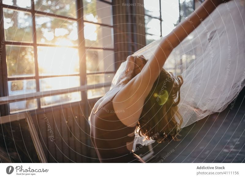 Slim woman dancing with veil in light studio dance grace ballerina expressive passion sensual flexible slim motion back bend tulle young dramatic female move