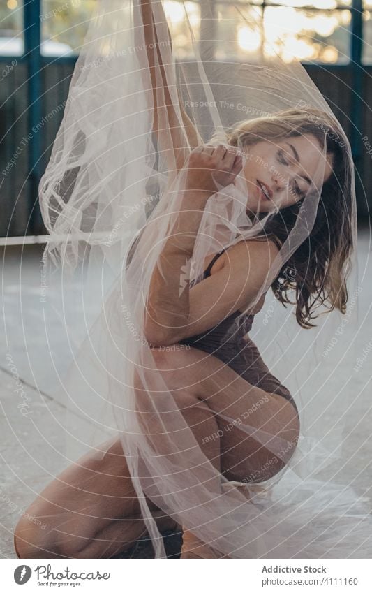 Alluring ballerina with transparent veil in studio woman dance sensual mystery ethereal grace pure art romantic slim light flexible motion tulle young female