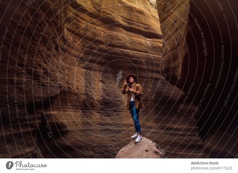 Woman standing on stone in ravine travel rock nature woman adventure explore tourism vacation mountain journey hike canyon female extreme holiday gorge activity