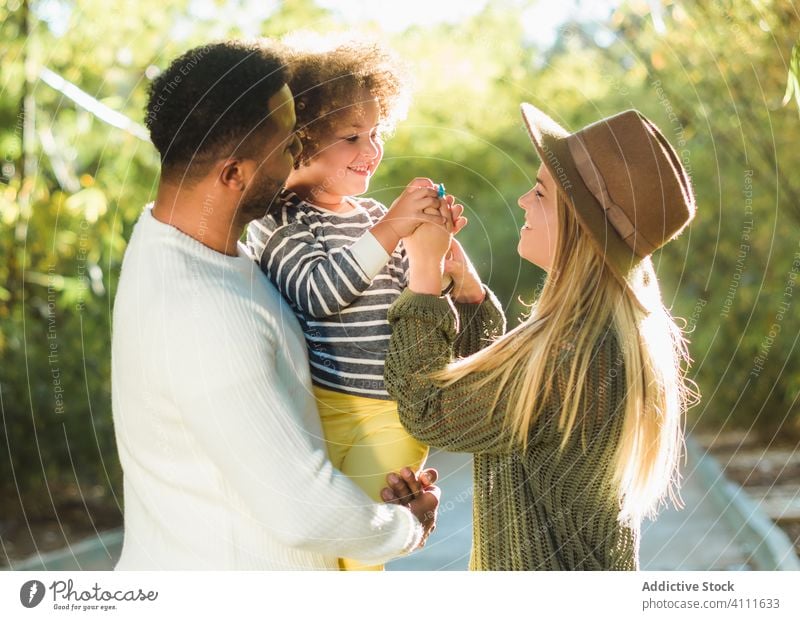 Happy family having fun in park together happy love kid embrace cheerful summer child parent bonding smile affection relationship mother father childhood joy