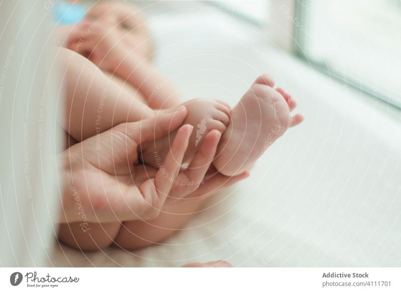 Tiny legs of tender infant on bed baby feet kid barefoot child lying mother small tiny skin little care adorable home cute comfort healthy innocent relax parent