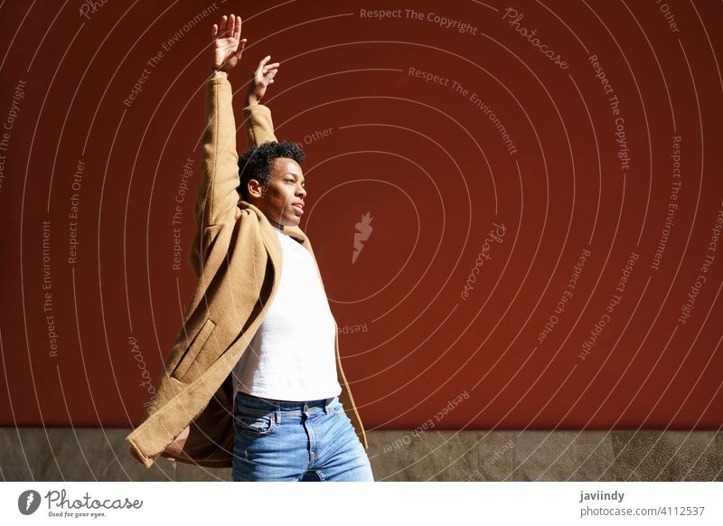 Young Cuban man dancing on red urban wall. black street happiness male cuban young expression person happy looking dancer outdoor one joy casual lifestyle adult