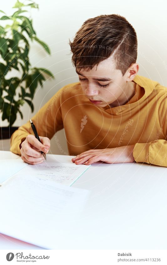 Teenage boy write homework at home. Education concept school writing studying education book person student people childhood caucasian desk young learning