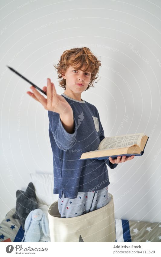 blond kid in pajamas with a book playing research children game protect happiness enjoyment room indoor party comfort emotional expression kids joyful