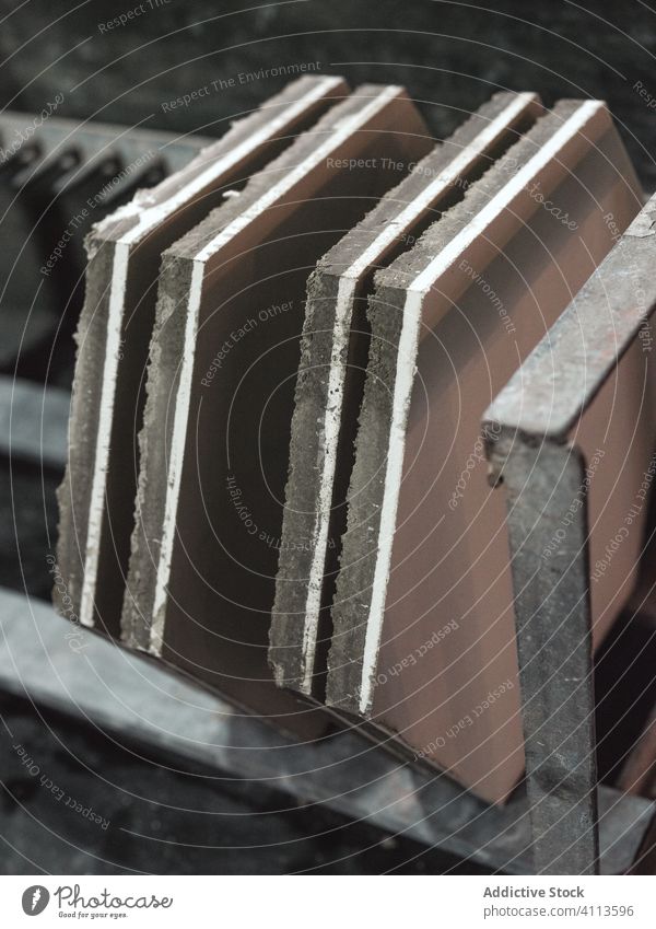 Row of hexagon shaped tiles on metal shelf in workshop ceramic manufacture handcraft raw geometry plain section element dry row production design panel storage