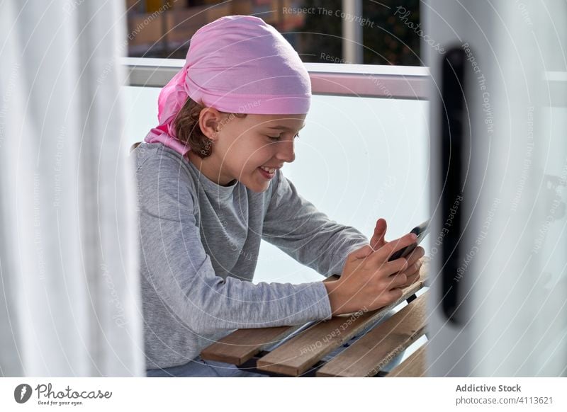 Happy boy using smartphone on terrace cancer disease enjoy pastime child cellphone male game play application communication connection contact surfing browsing