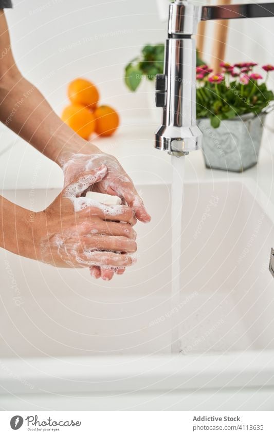 Woman washing her hands on the kitchen sink to avoid possible infection clean lifestyle hygiene home personal indoors faucet water cleaning house midsection