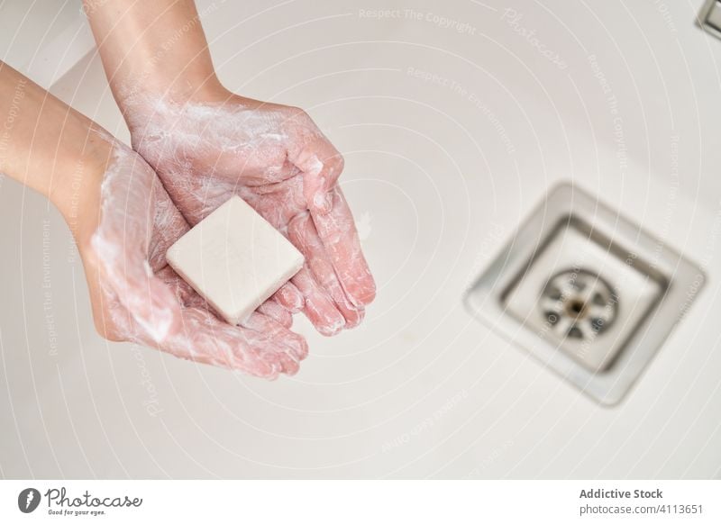 Blond child washing his hands in the kitchen sink to prevent any infection lifestyle kid indoors son boy water home young hygiene domestic childhood folding