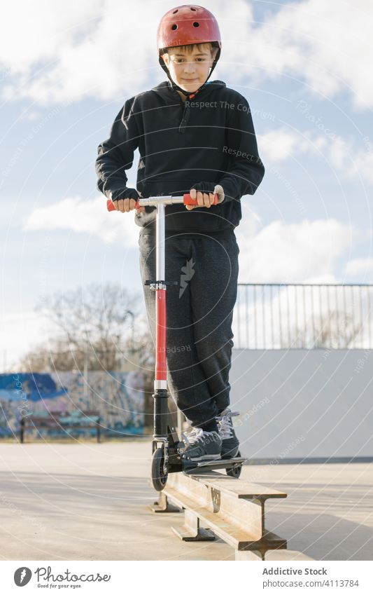 Boy riding scooter on ramp in park boy skate park extreme sport urban active practice ride kick teen teenage trick skateboard male stunt street lifestyle hobby