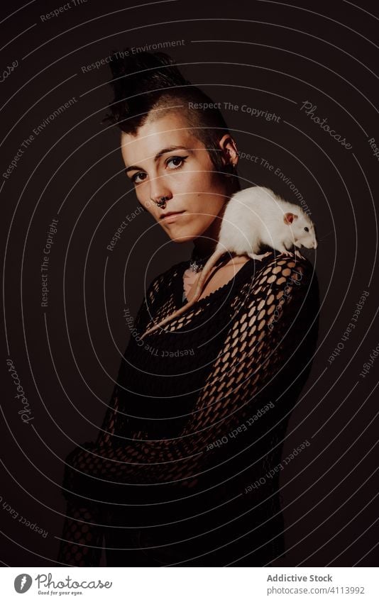 Female punk with rat on shoulder woman style confident pet subculture modern rebel mohawk appearance female dark model piercing individuality personality