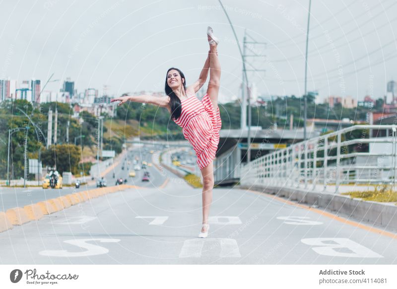 Happy woman dancing on road dance ballet grace concept outskirts split smile young female slim elegant ballerina perform city traffic modern dancer move