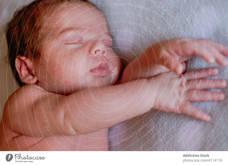 Sweet newborn sleeping in soft bed at home relax baby kid infant calm innocent rest little peaceful child cute face head silent comfort nap hand harmony