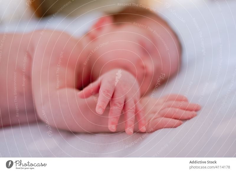 Sweet newborn sleeping in soft bed at home relax baby kid infant calm innocent rest little peaceful child cute face head silent comfort nap hand harmony