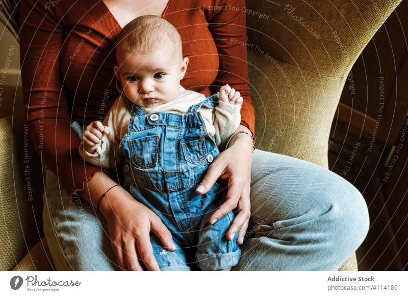 Mother with baby sitting near window mother baby talk chair home cozy comfort casual happy cute love tender woman infant adorable barefoot child kid smile