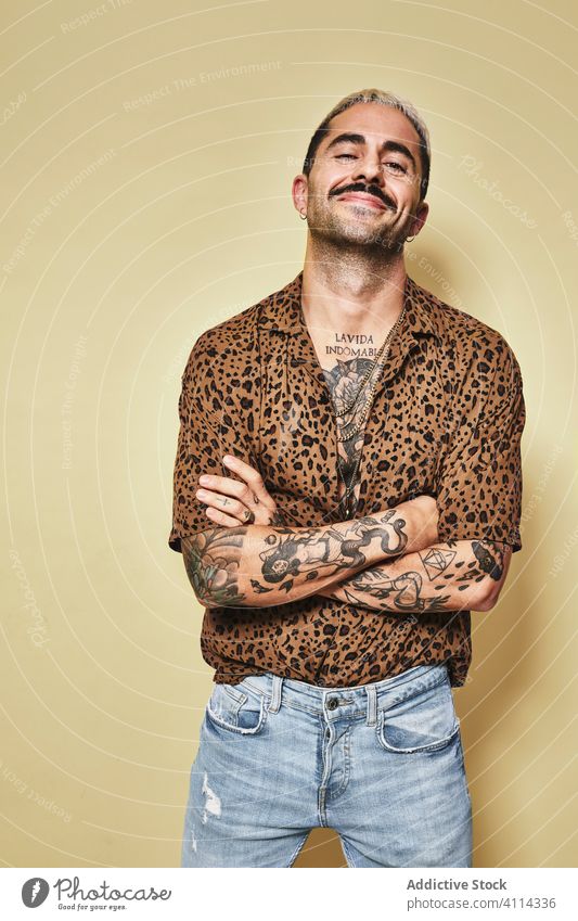 Trendy ethnic guy in stylish outfit standing in studio man trendy style cheerful fashion leopard model jeans male cloth modern cool confident handsome smile