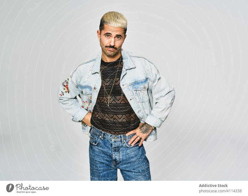 Stylish grimacing man in denim outfit trendy independent expressive grimace style modern hipster ethnic male jacket mustache confident fashion contemporary