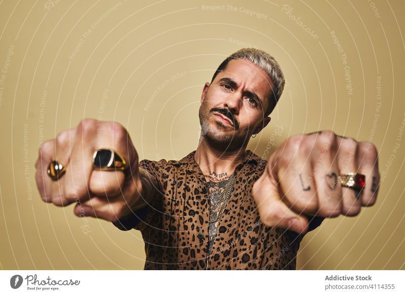 Brutal cool man with tattooed hands in rings gangster style brutal provocative macho fashion hipster fist trendy outfit serious beard male modern eccentric