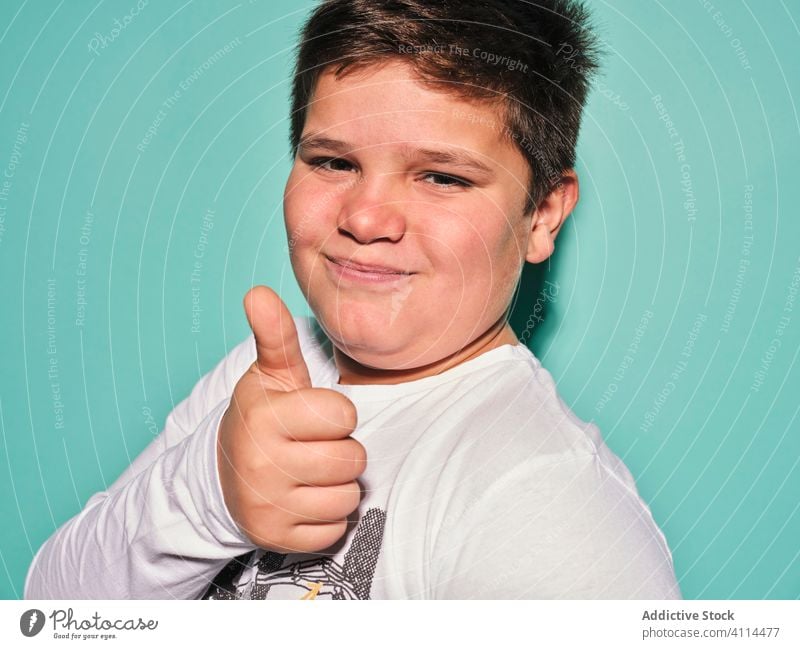 Happy young man smiling at camera gesturing thumbs up boy preteen child happy rebel confident cool schoolboy brunet smile kid cheerful childhood hand short hair