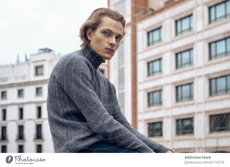 Confident young man looking at camera trendy serious confident street modern style sweater handsome urban city casual contemporary fashion gray haircut