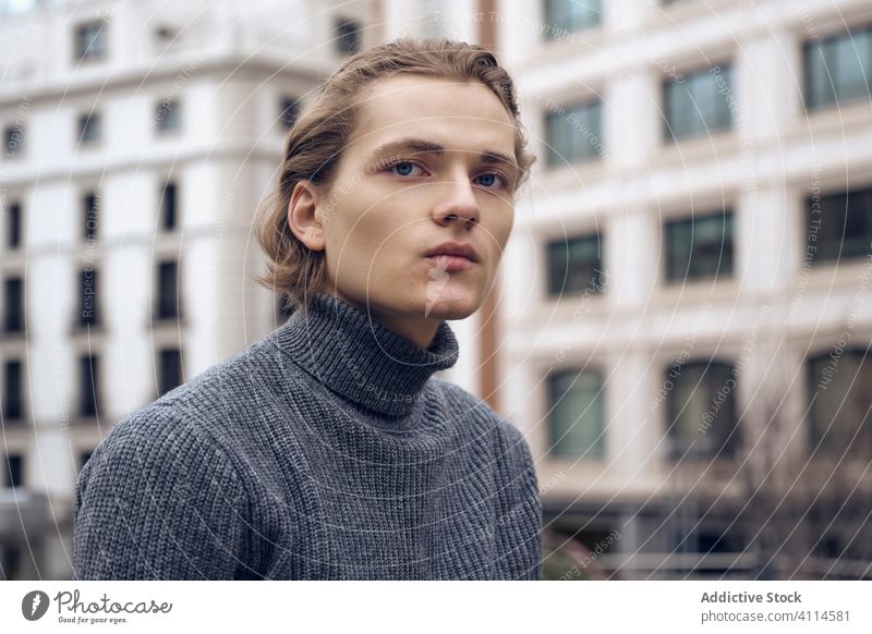 Confident young man looking at camera trendy serious confident street modern style sweater handsome urban city casual contemporary fashion gray haircut