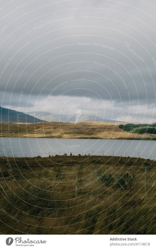 Autumn landscape with lake and cloudy sky overcast highland hill gloomy gray calm tranquil scotland nature travel mountain terrain countryside water tourism