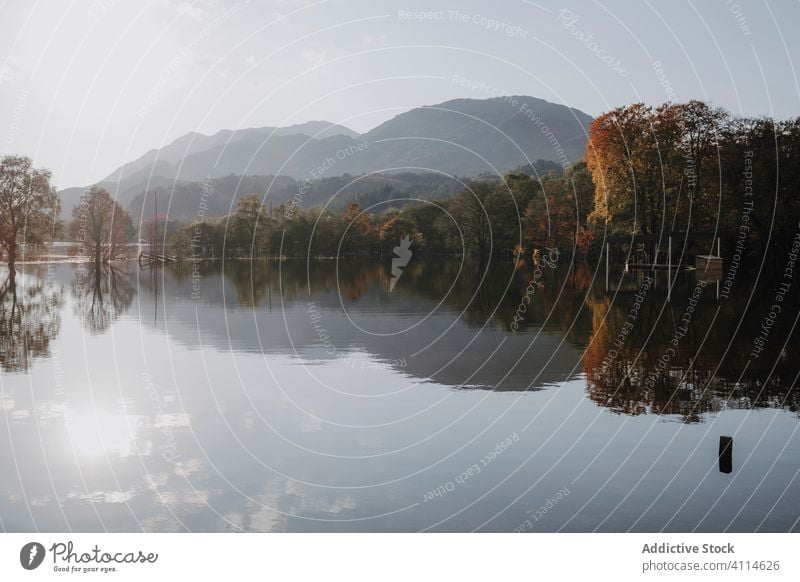 Calm lake reflecting rocky mountains reflection sunny landscape highland cloud tree calm tranquil water nature peaceful scotland shore travel tourism