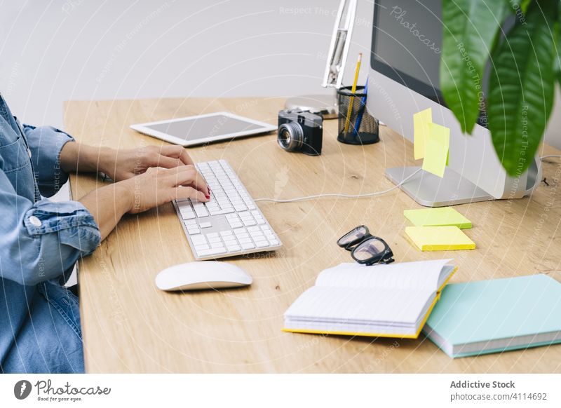 Blonde Caucasian woman works from her home office browsing computer typing desk communication businesswoman tablet indoor adult laptop desktop design lifestyle