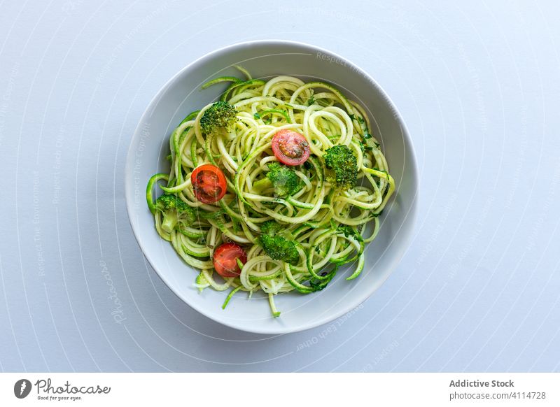 Homemade zucchini spaghetti with pesto sauce, broccoli and cherry tomatoes plate organic healthy green vegetarian raw spiral diet agriculture farming homemade