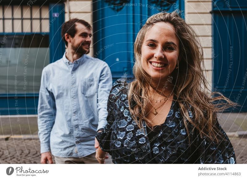 Joyful young couple walking on street city happy together building old cheerful smile follow travel holiday casual romantic love relationship lifestyle urban