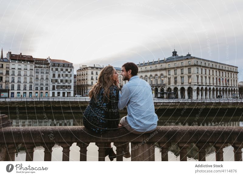 Happy couple enjoying time together in romantic city love relationship embrace happy fence stone travel boyfriend france bayonne girlfriend hug date affection