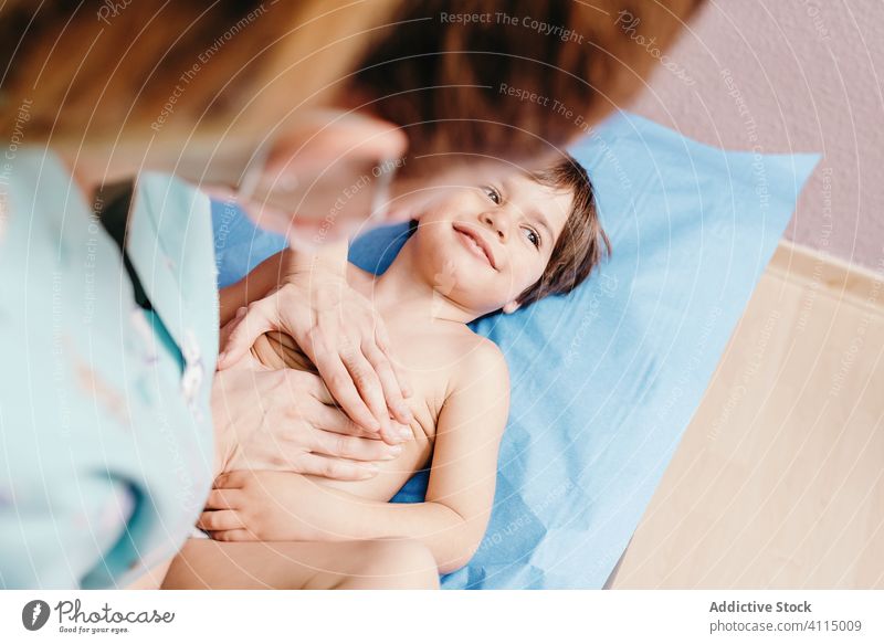 Nurse examining little boy in clinic child examine nurse doctor cheerful lying woman patient hospital kid chest respiratory mask care specialist health care