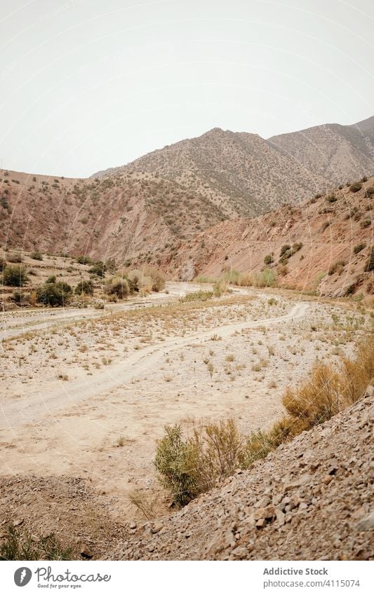 Desert landscape of mountainous terrain with road desert dry valley countryside nature africa morocco travel tourism empty curve route sand scenery hill way hot