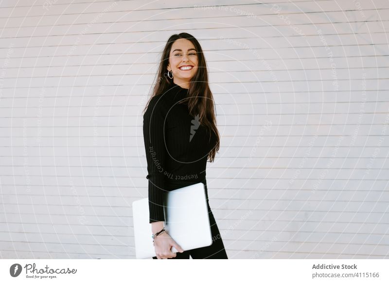 Happy woman with laptop walking on street wall smile city carry young modern female pedestrian student happy computer urban excited lifestyle trendy casual