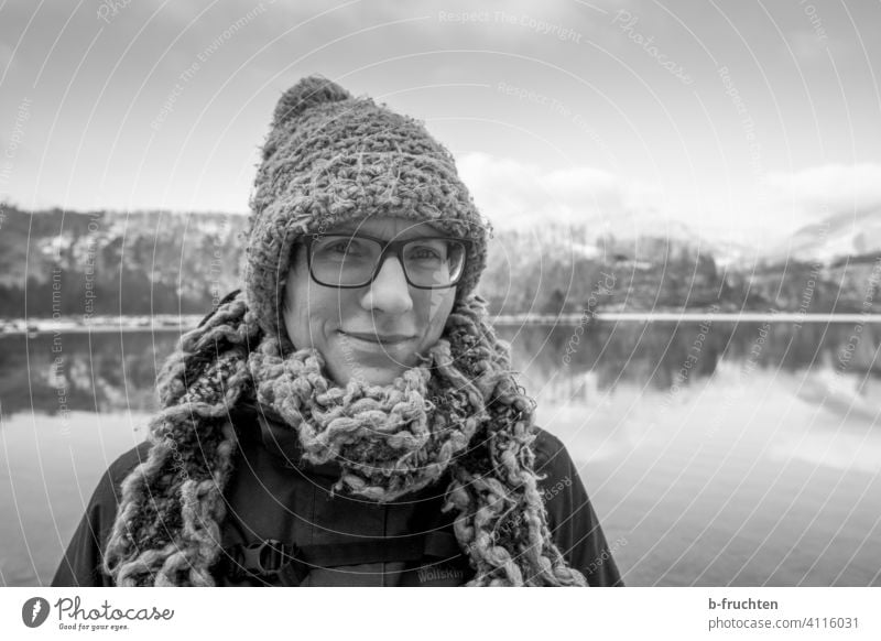 Woman with wool cap and wool scarf in front of a mountain lake portrait Scarf Wool Woolen hat Cap Winter Cold Lake Lakeside Face Adults Clothing Alps