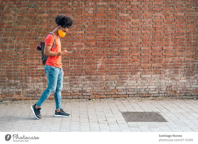 Afro American Boy Walking walking side view afro young man face mask wearing mask boy black african american urban outside lifestyle technology fun modern