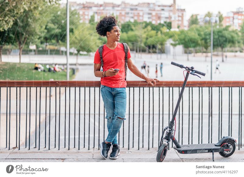 African American Boy in Street afro young man boy black african american smiling urban front view electric scooter outside device happy looking at side riding