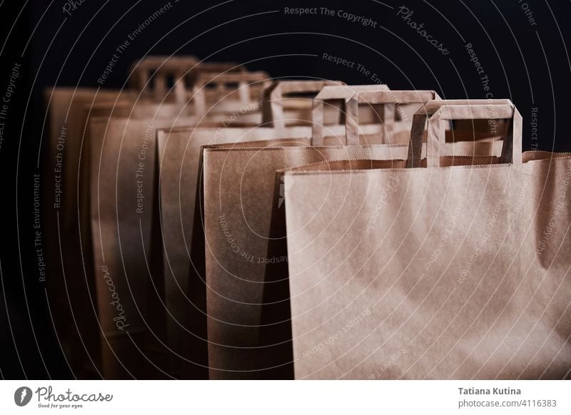 Brown paper bags on a black background zero waste package purchase several shopping retail brown carry empty group white closeup commerce consumerism handle