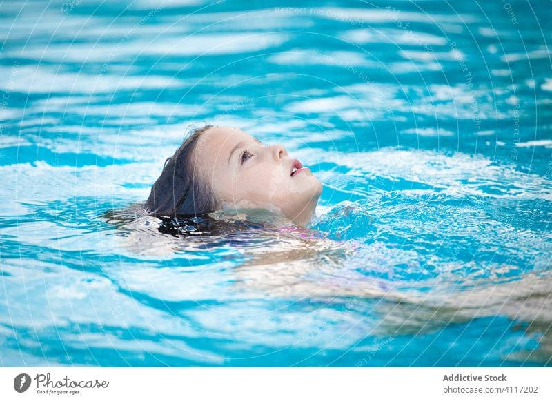 Little girl floating in pool water relax joy clean wet swim kid child rest resort lifestyle summer cute adorable pleasure recreation weekend serene tranquil