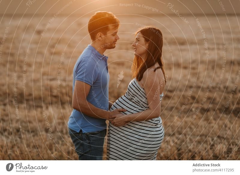 Couple awaiting baby in field couple pregnant hay field sunset love touch belly together tender countryside man woman nature expect relationship maternal happy