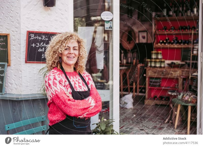 Female seller near shop entrance woman confident arms crossed smile cozy local food friendly small business female adult cheerful happy positive joy casual