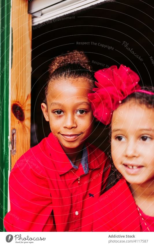 Cheerful ethnic children looking out window kid house happy sibling together cheerful wooden rural smile home lifestyle countryside joy little casual sister